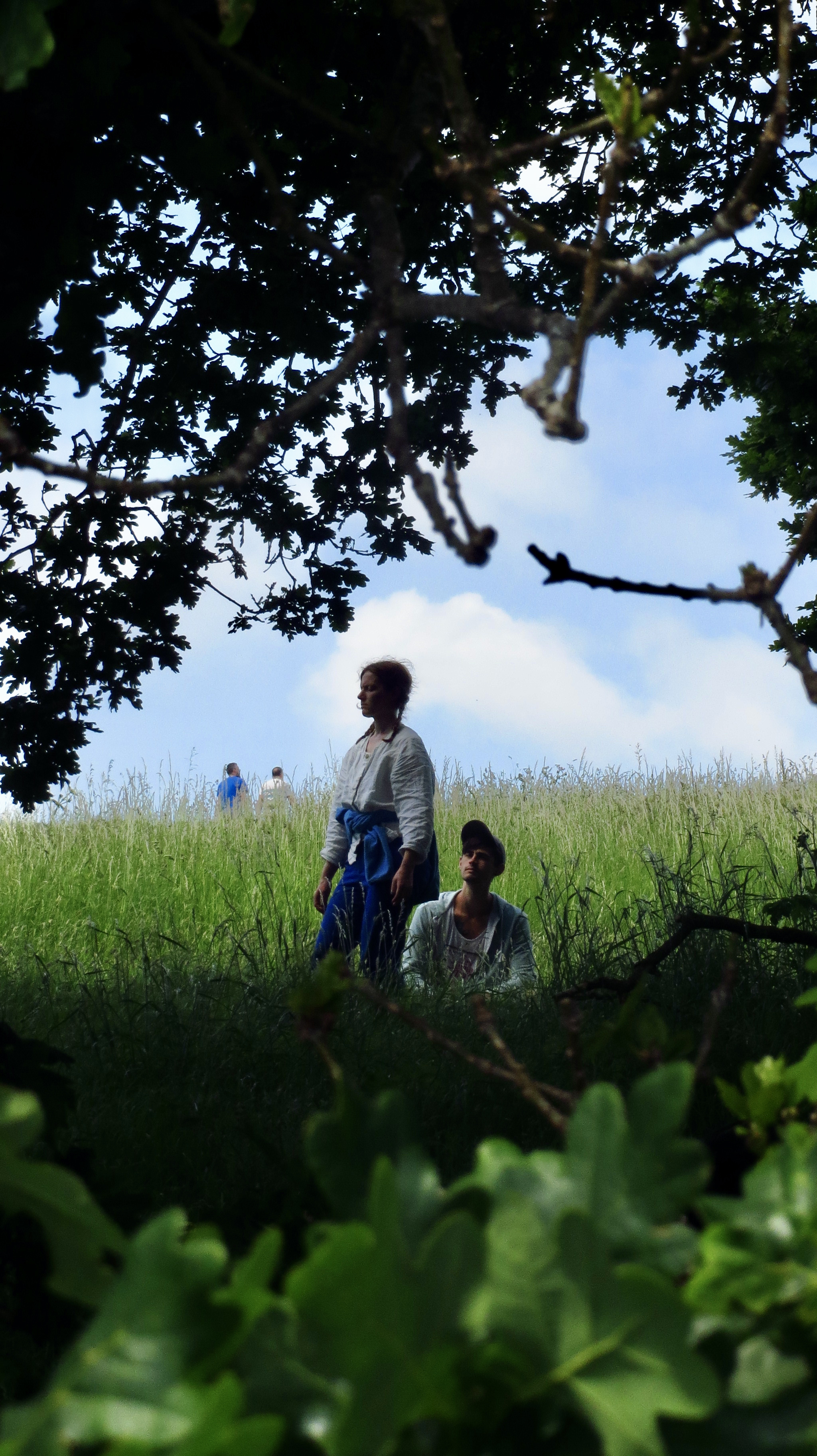 two people spotted in the shadow of an oak tree